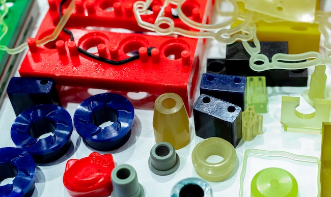 Acrylonitrile butadiene styrene (ABS) plastic components in various molded shapes, demonstrating durable thermoplastic materials used in industrial and consumer applications.